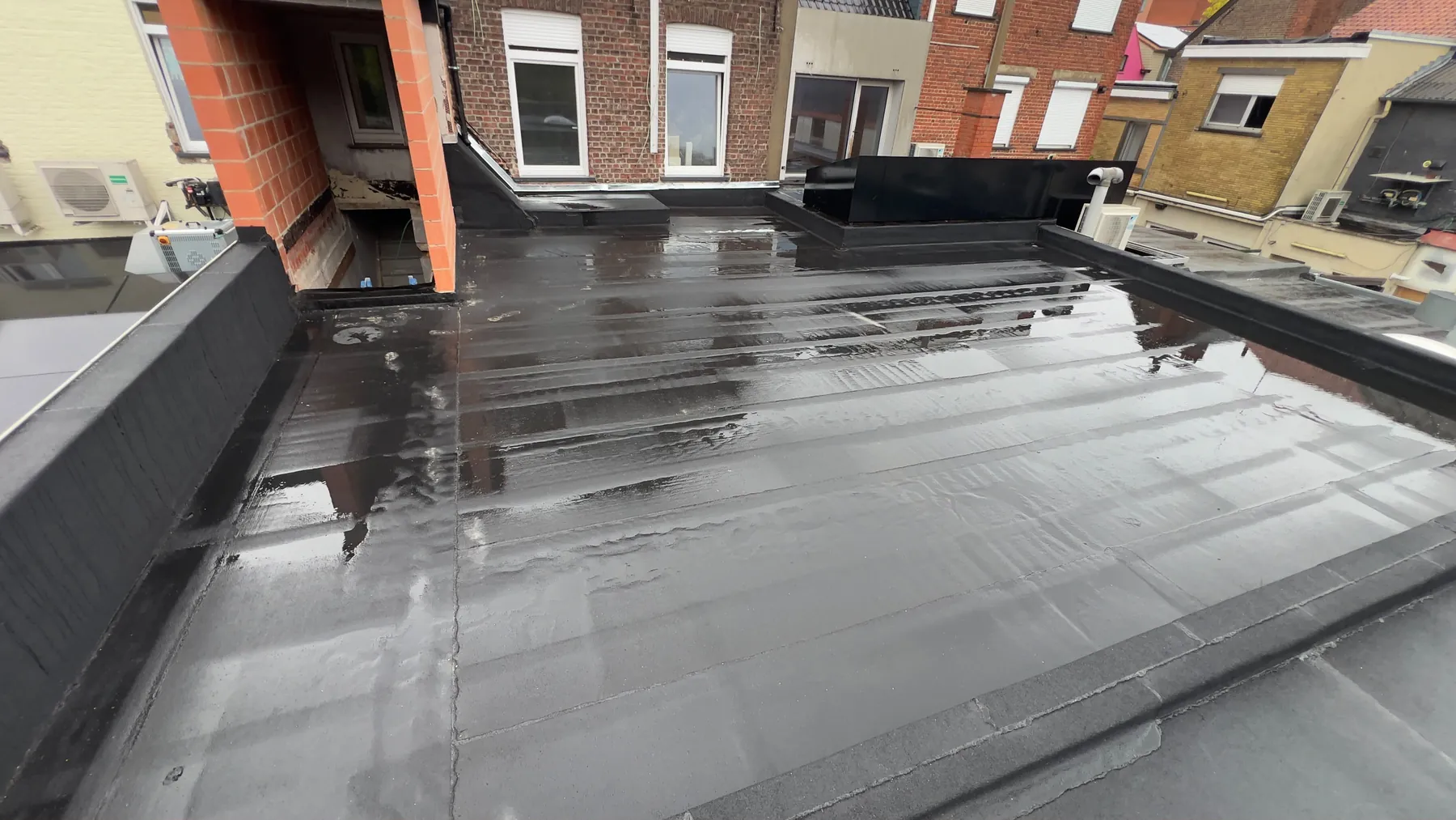 Het afgewerkte platte dak langs de gevels